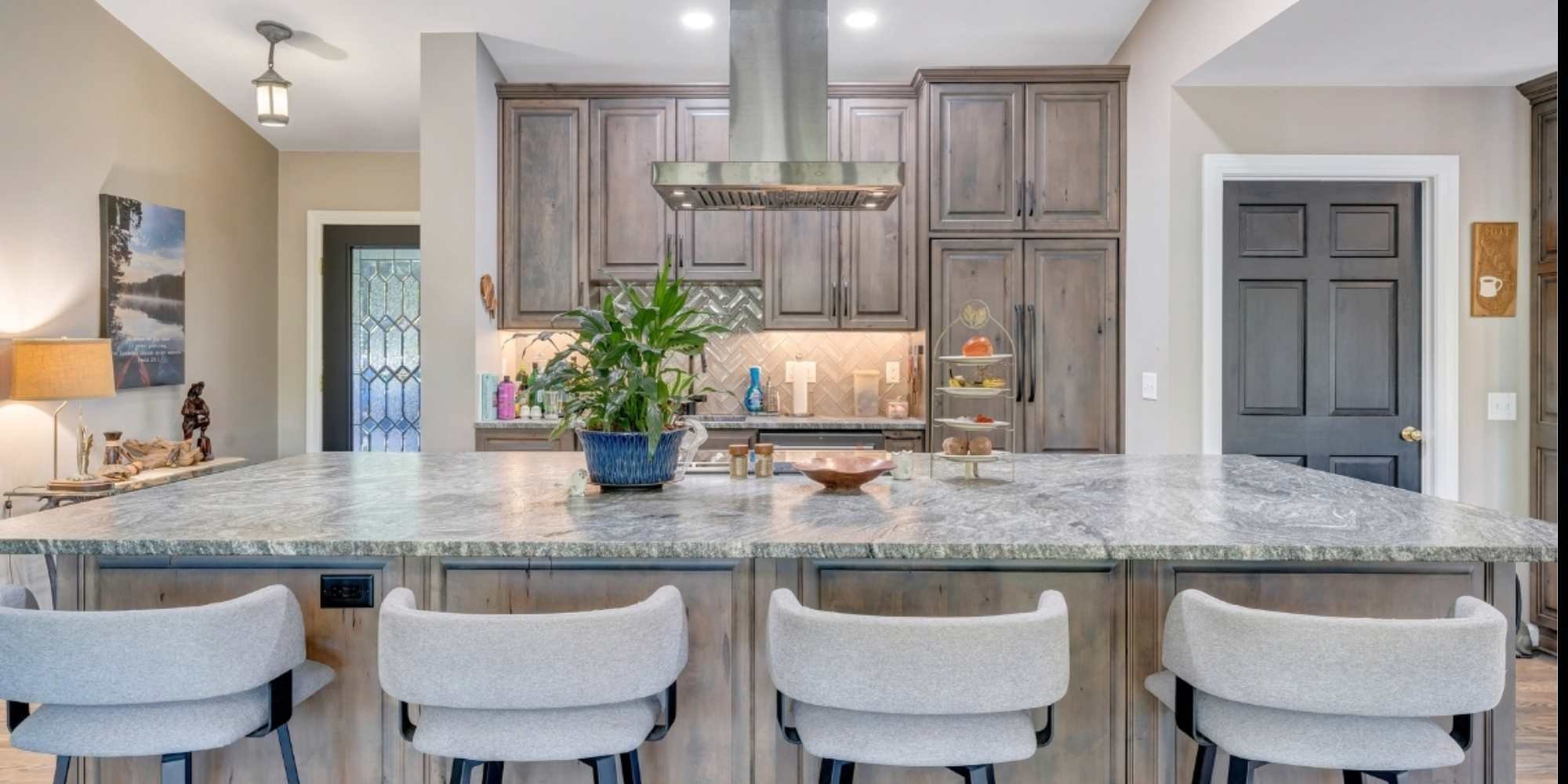 A bright, modern kitchen in a Smith Mountain Lake home addition by Grace Alon Builders featuring a large island with seating.