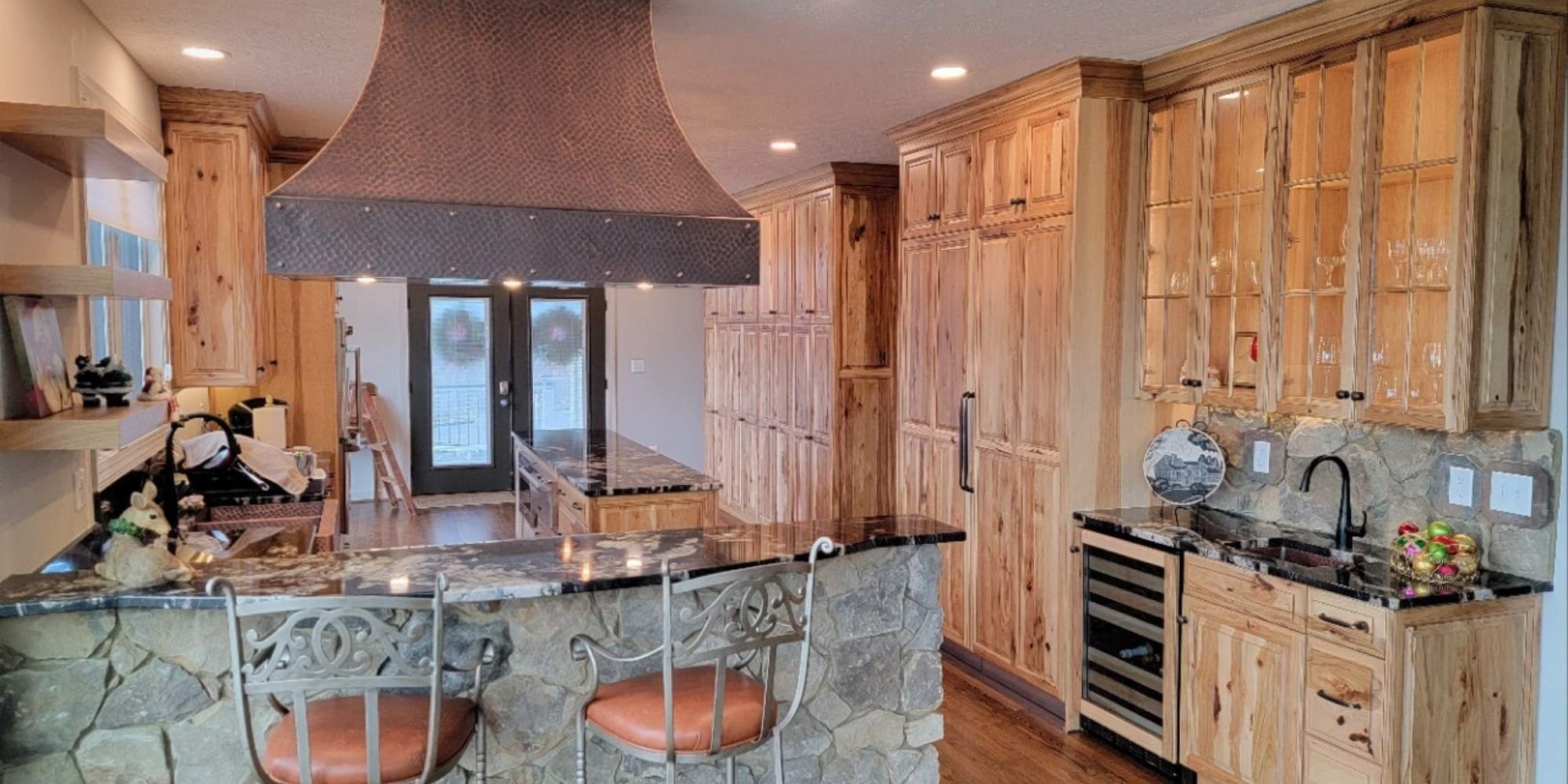 Grace Alon Builders remodeled this warm kitchen with knotty wood cabinetry and stone bar in Roanoke County