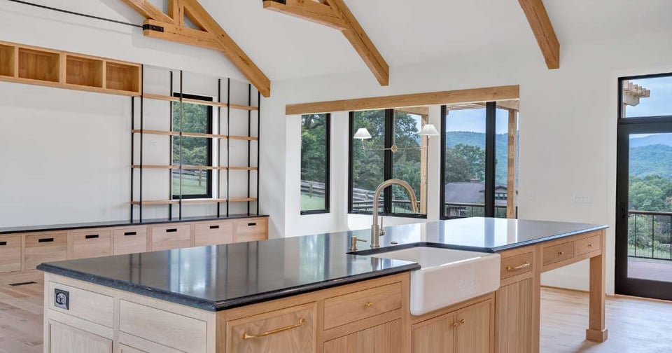 Natural wood custom kitchen with black countertops and panoramic windows in Roanoke County by Grace Alon Builders