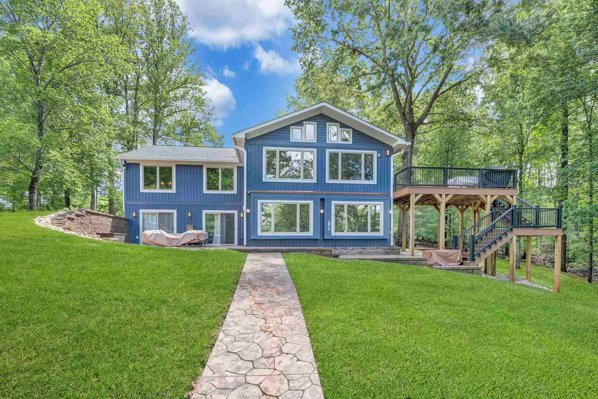 Custom lakefront home exterior by Grace Alon Builders in Smith Mountain Lake featuring large windows and elevated deck