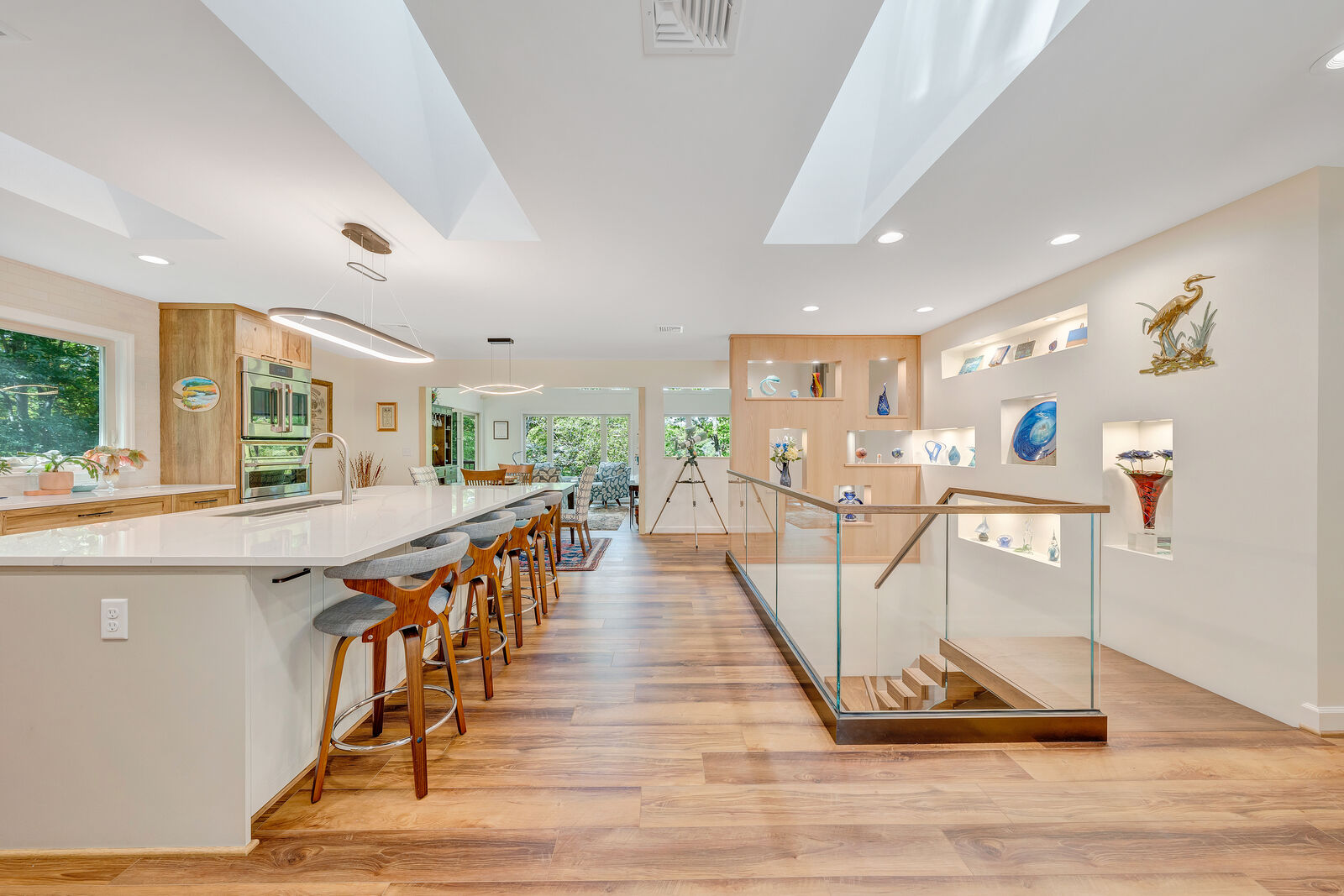 Open-concept kitchen and dining area in Smith Mountain Lake home by Grace Alon Builders with skylights and bar seating