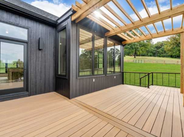 Modern custom home deck with pergola and black-trimmed windows by Grace Alon Builders