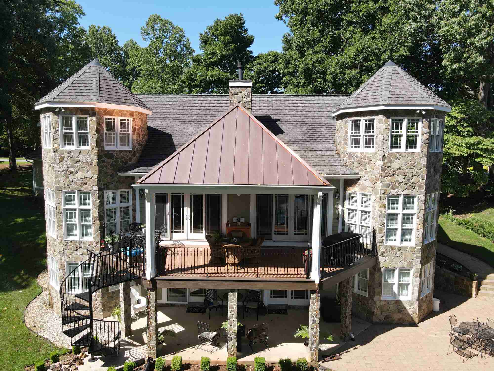 Stone-clad custom home with turret towers in Roanoke Metropolitan by Grace Alon Builders