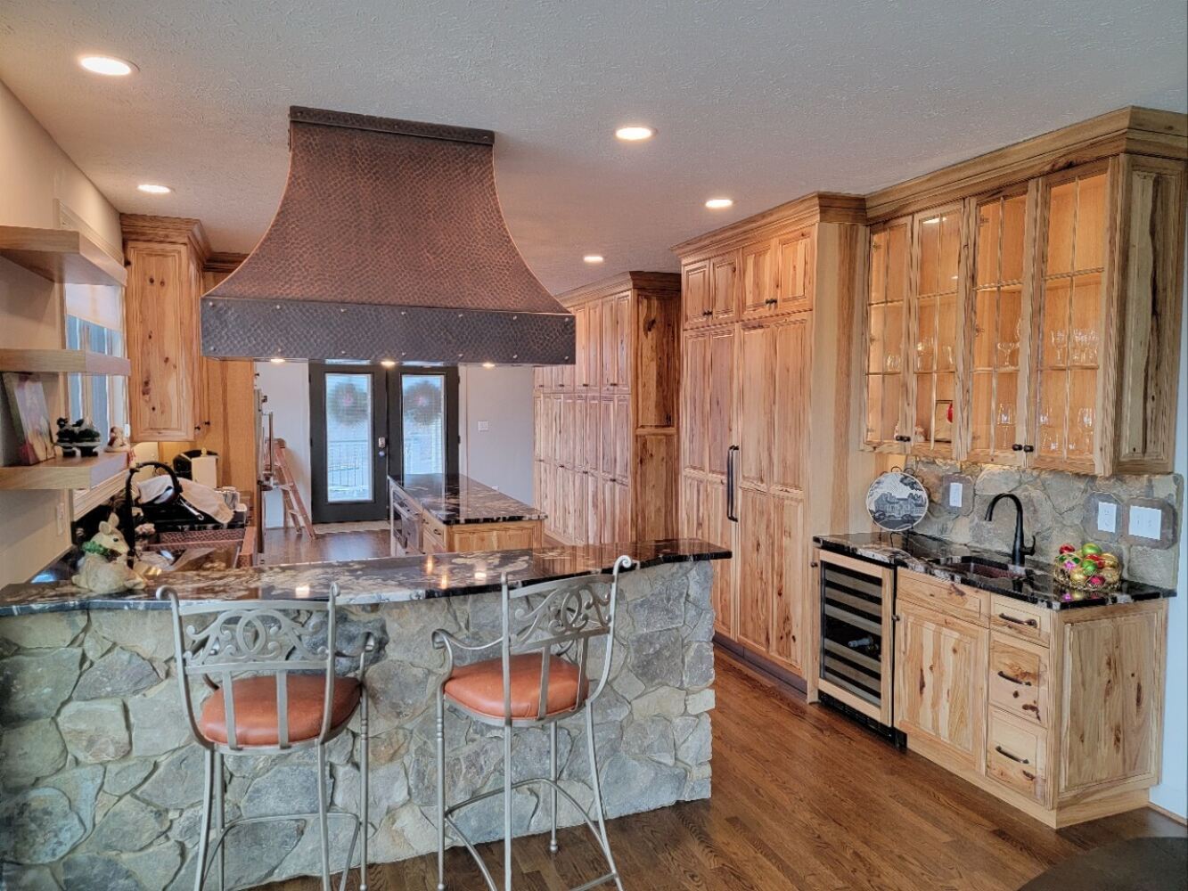 Rustic-style kitchen with natural wood cabinets and stone bar by Grace Alon Builders in Roanoke Metropolitan