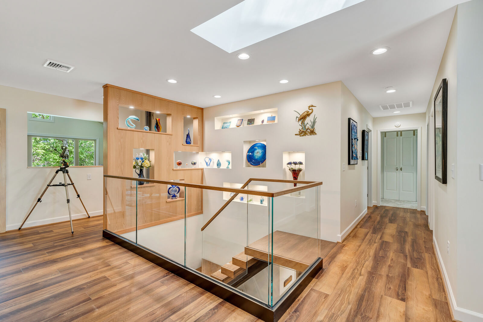 Grace Alon Builders custom home hallway in Smith Mountain Lake with wood floors and art display