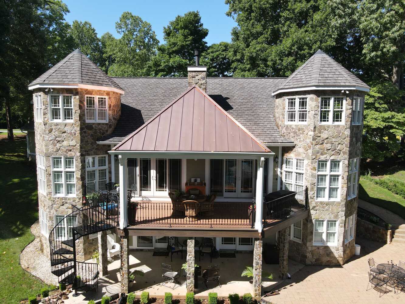 Stone-clad custom home with turret towers in Roanoke Metropolitan by Grace Alon Builders
