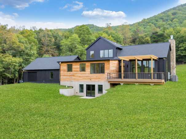 Back view of custom home by Grace Alon Builders with mixed siding and elevated deck